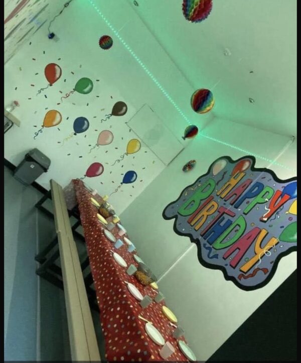 A room with balloons and cupcakes on the wall