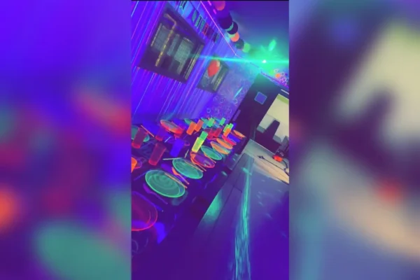 A room with neon lights and tables in it
